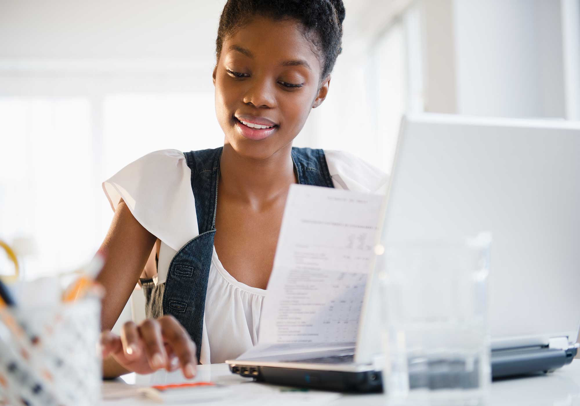 A woman sitting down looking at her bank statement.