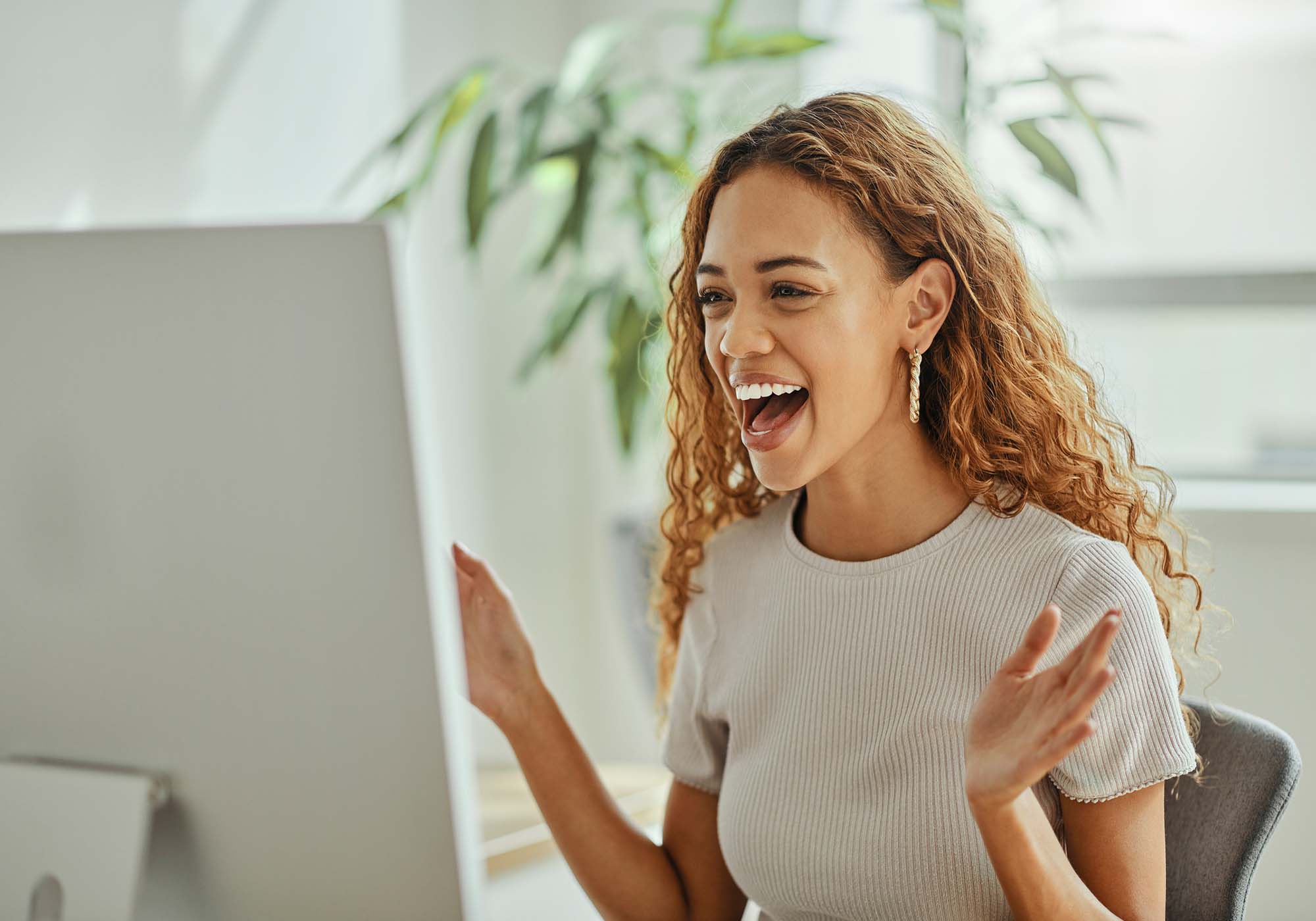 excited woman looking at computer screen 