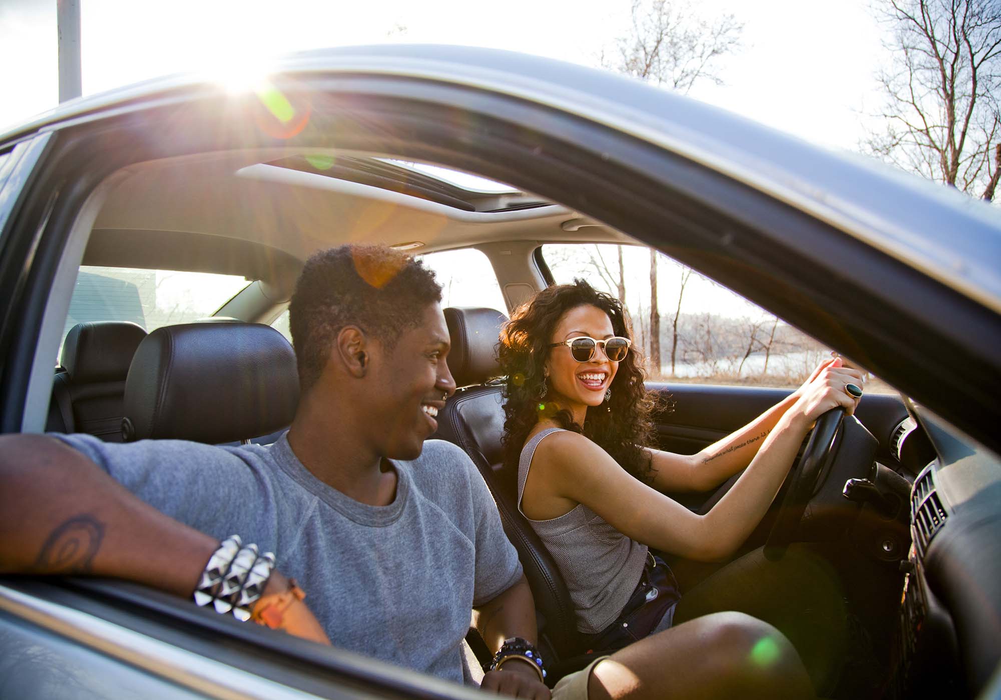 young couple smiling in car with windows open