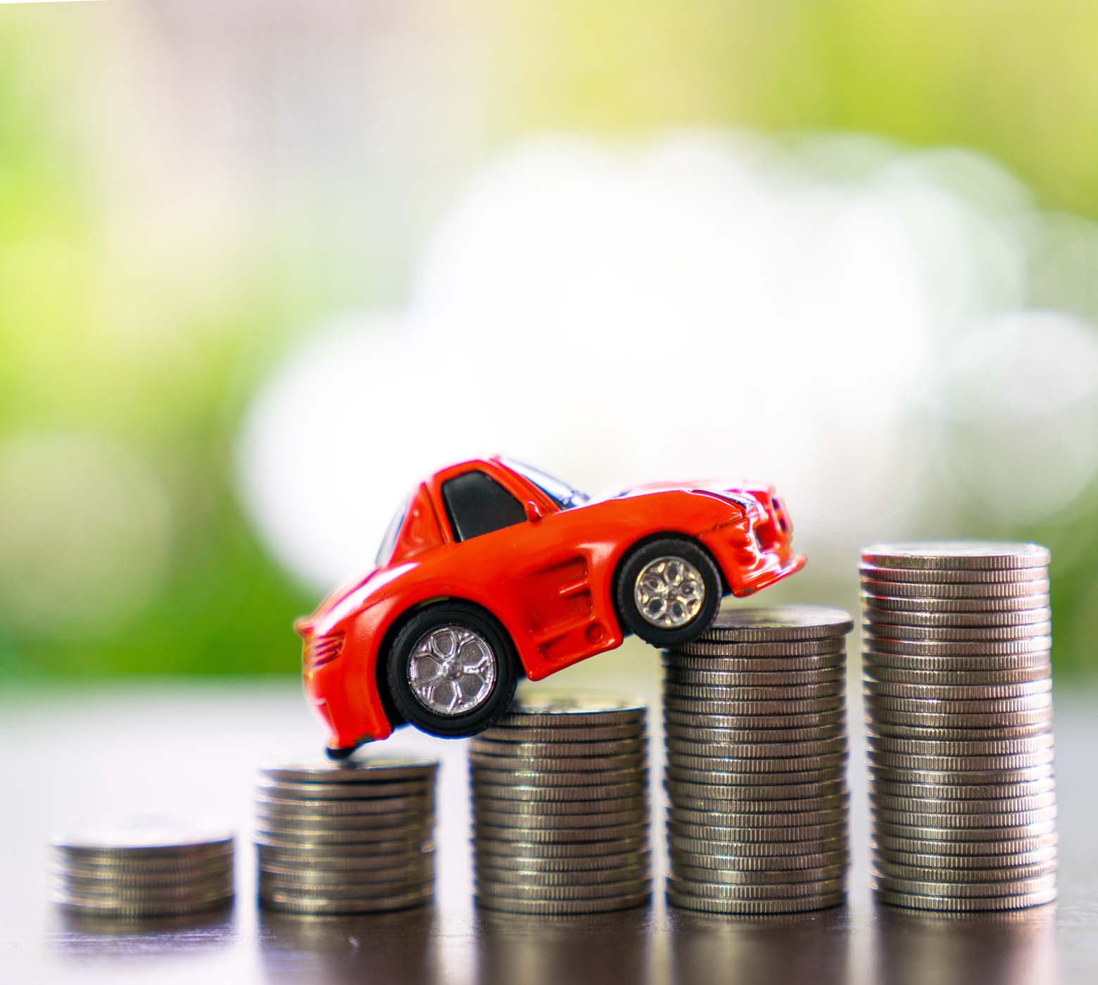 red toy car on stack of coins