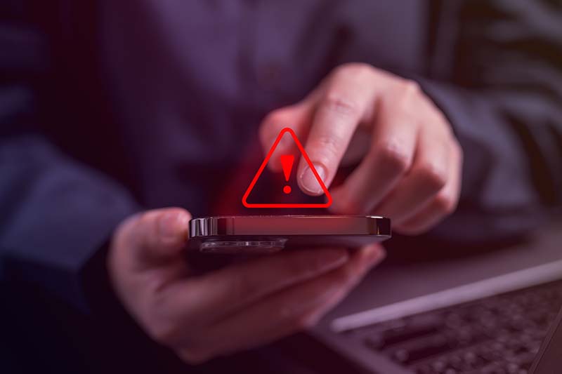 person using iPhone with red alert symbol 