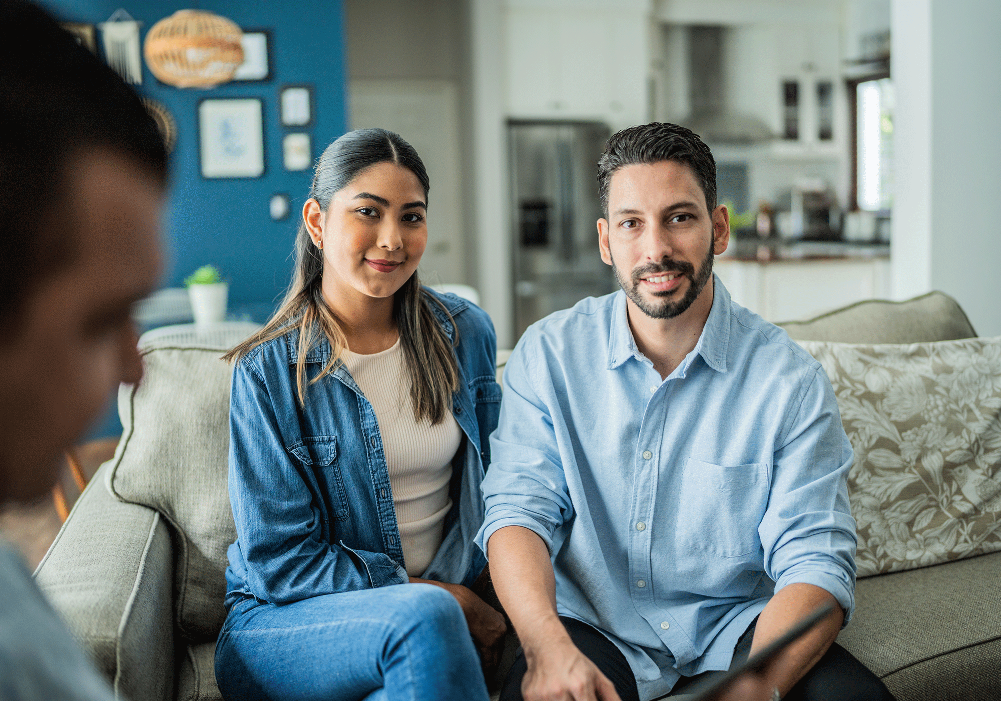 A happy couple sitting on their sofa.