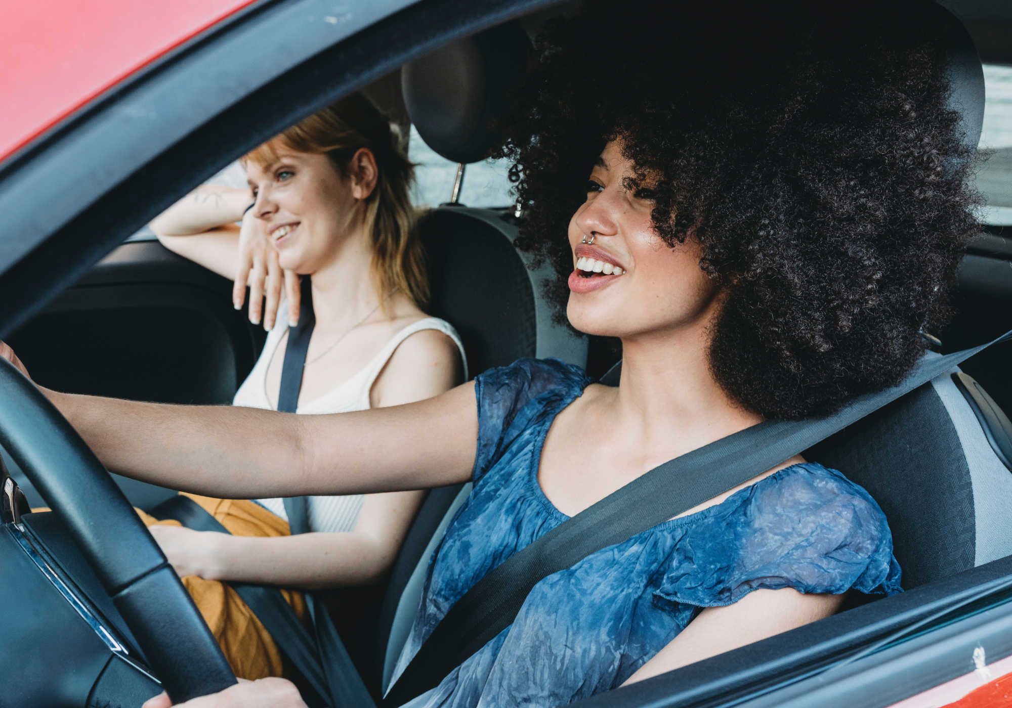 two happy women sitting in newly purchased used vehicle