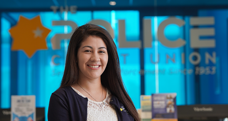 Member Services Representative in front of The Police Credit Union Logo 