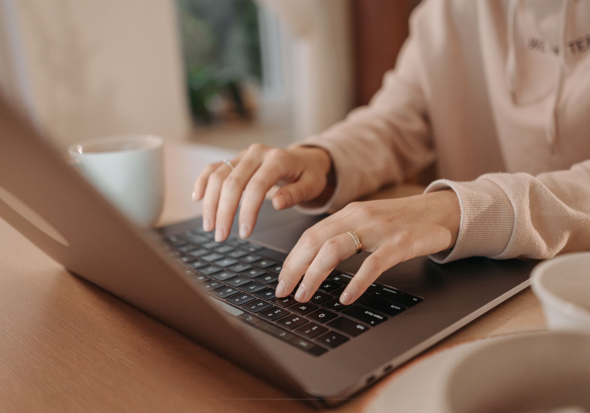 Hands typing on a laptop